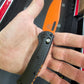 B-USA 15533or-01 M*NI TAGGED OUT CARBON FIBER W/ ORANGEBLADE KNIFE. MADE on a BENCH in Oregon