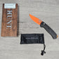 B-USA 15533or-01 M*NI TAGGED OUT CARBON FIBER W/ ORANGEBLADE KNIFE. MADE on a BENCH in Oregon