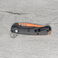 B-USA 15533or-01 M*NI TAGGED OUT CARBON FIBER W/ ORANGEBLADE KNIFE. MADE on a BENCH in Oregon